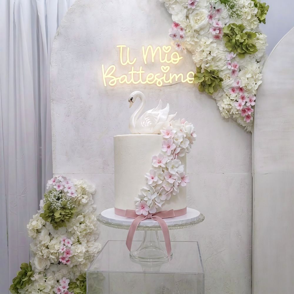 Torta scenografica per battesimo a tema cigno realizzata da Alessia Vincenti Party Design Roma. Decorazioni floreali delicate e topper cigno artistico