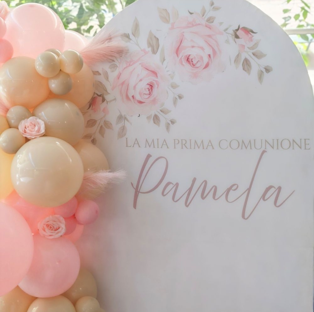 Dettagli di stampa personalizzata su tessuto di un allestimento tema comunione con scritta la mia prima comunione nel colore beige e scritta nome Pamela nel colore rosa. la stampa presenta in alto decorazioni stampate di fiori di rosa e foglie beige rosate, sulla sinistra composizione di palloncini rosa e beige con rose rosa, Grafica a cura di Alessia Vincenti party designer a Roma