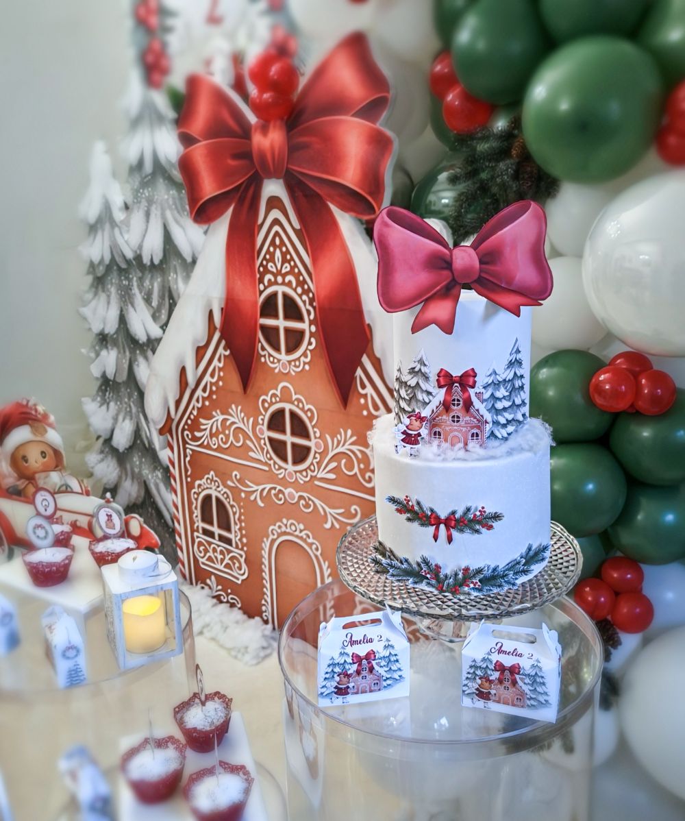 Allestimento compleanno tema Pan di Zenzero a Roma: scenografia artigianale di Alessia Vincenti con fondale a casetta, torta personalizzata, personaggi sagomati, ghirlanda di palloncini natalizi e scatoline regalo coordinate.
