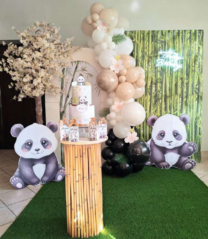 Allestimento tema panda con decorazioni di albero di ciliegio, sfondo personalizzato, scritta al led happy Birthday, ghirlanda di palloncini nei colori nero sabbia bianco, tavolo in bambù, torta scenografica e scatoline coordinate, allestimento realizzato da Alessia Vincenti Roma 