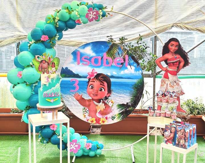 Allestimento tema Vaiana con grafica personalizzata, cerchio bianco decorato con palloncini verde acqua e Tiffany, arricchito con fiori, sagoma Vaiana, Torta scenografica, regalini fine festa e cupcake, realizzato da Alessia Vincenti Roma