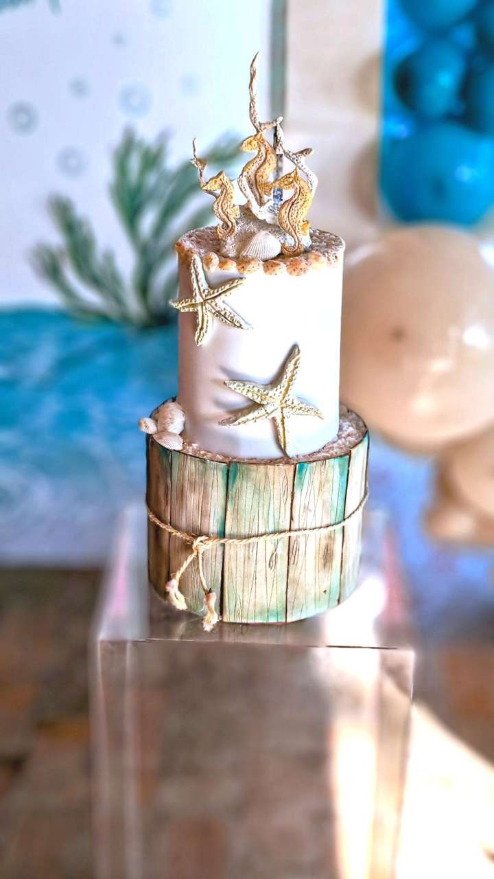 Torta tema mare, dipinta a mano con decori realizzati a mano in porcellana fredda di conchiglie stelle marine e cavallucci marini realizzata da Alessia Vincenti Roma